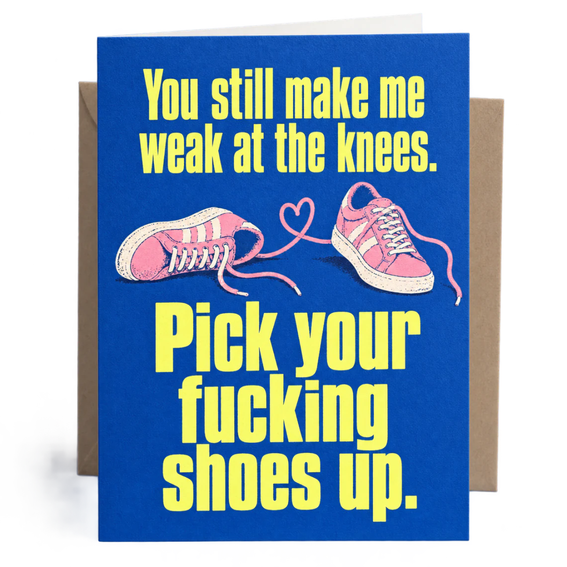 Cobalt blue anniversary card with pink trainers and yellow wording: You still make me weak at the knees. Pick your fucking shoes up.