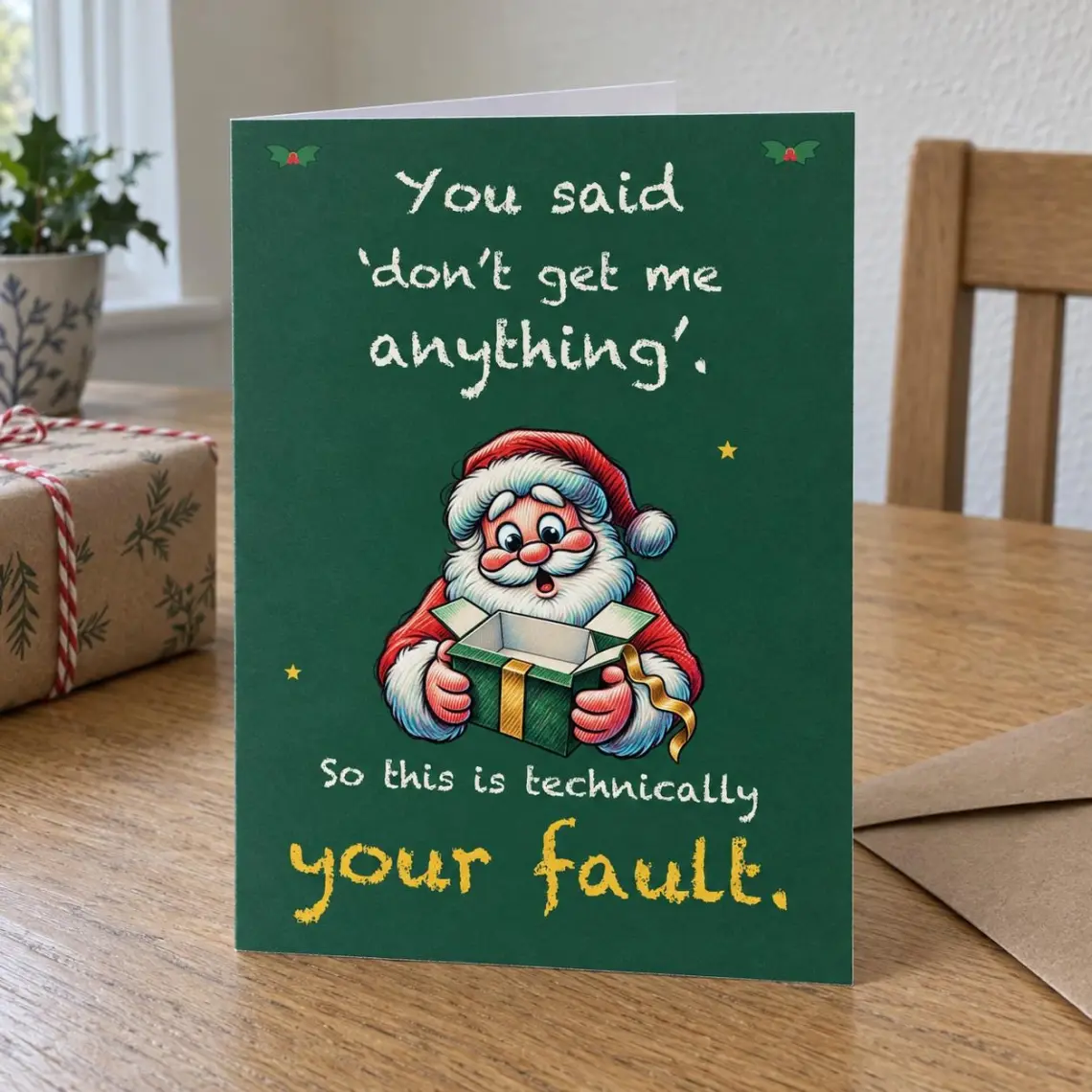 Dark green Christmas card with Santa staring into an empty gift box, reading: You said don't get me anything. So this is technically your fault.