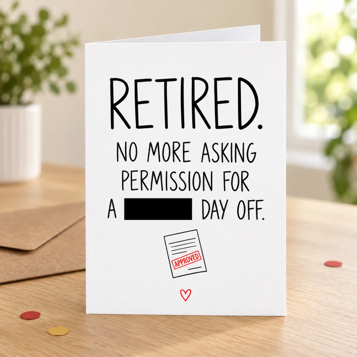 Lifestyle mock-up of a standing retirement card about permission for a day off, with one word covered by a black bar and an APPROVED-form doodle. On a wooden table beside a kraft envelope and red/gold confetti.